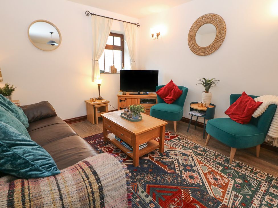 A living room with a coffee table and two armchairs at Win Hill View Cottage in Hope Valley