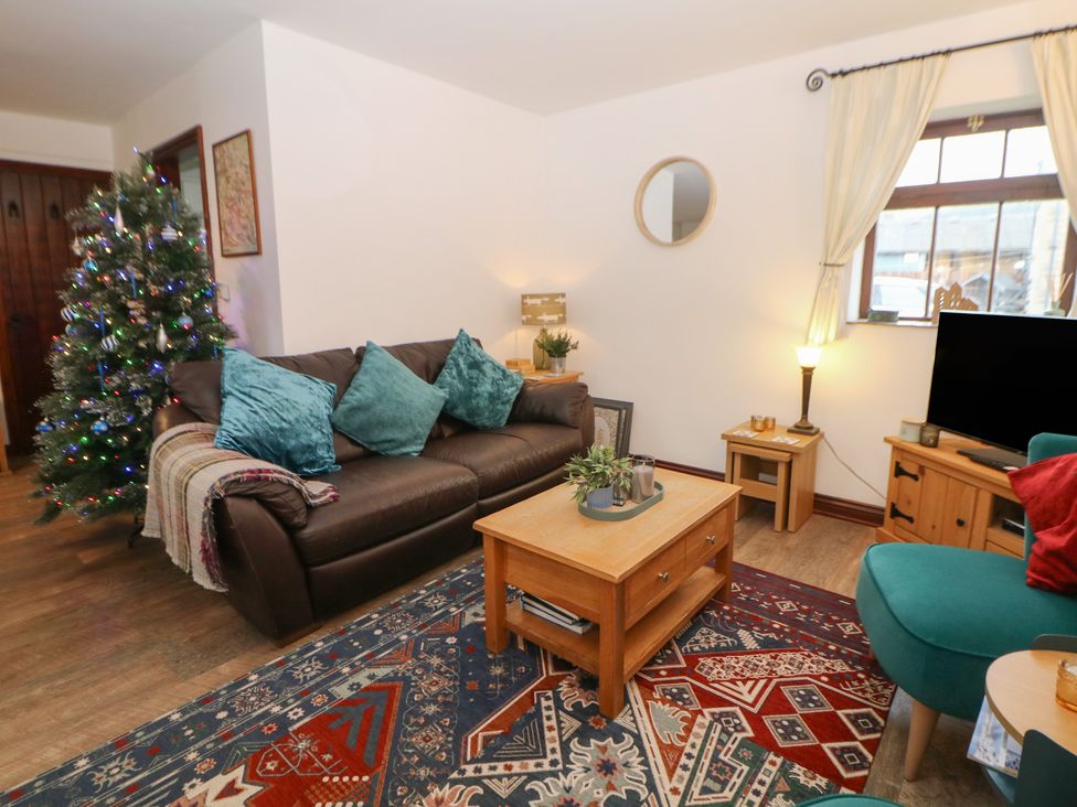 A living room with a sofa and coffee table at Win Hill View Cottage in Hope Valley