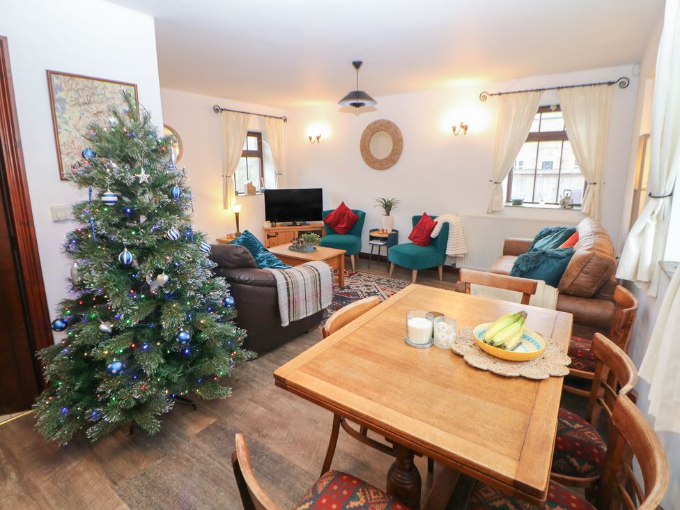 A living room with a Christmas tree and seating area at Win Hill View Cottage in Hope Valley