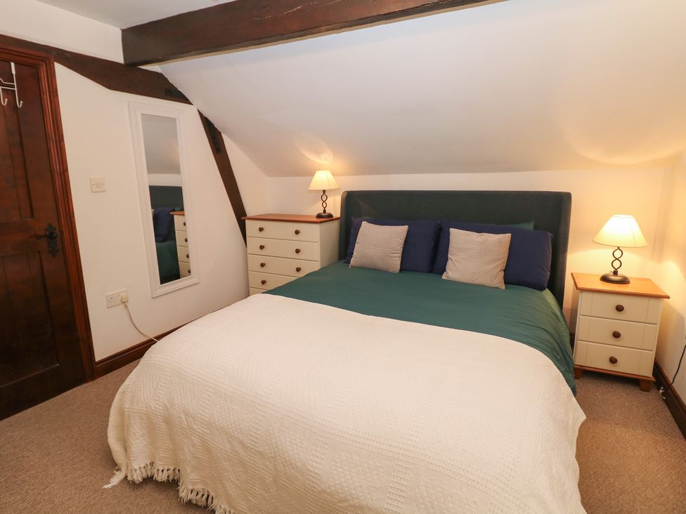 A bedroom with a bed and bedside table at Win Hill View Cottage in Hope Valley