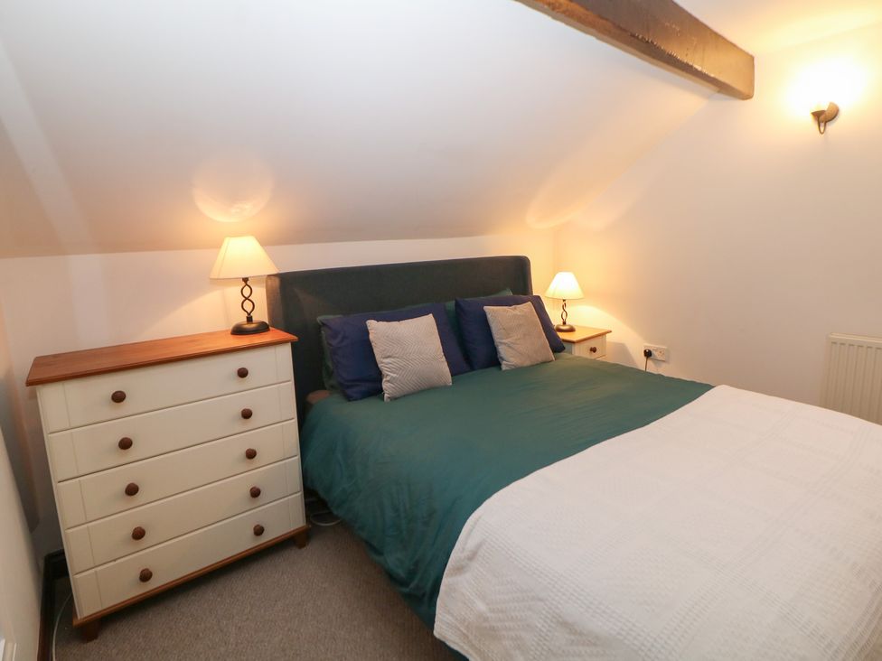A bedroom with a bed and bedside lamp at Win Hill View Cottage in Hope Valley