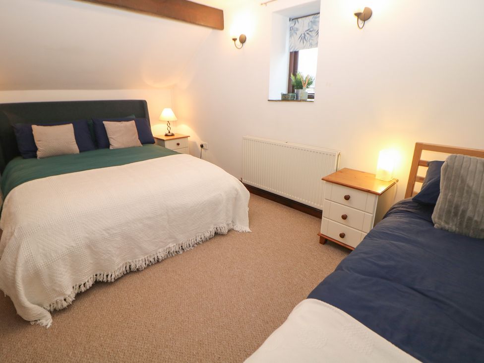 A bedroom with a double bed and a single bed at Win Hill View Cottage in Hope Valley