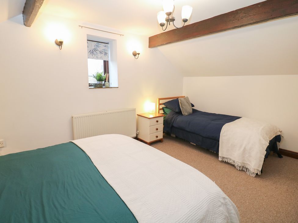 A bedroom with two beds and a window at Win Hill View Cottage in Hope Valley