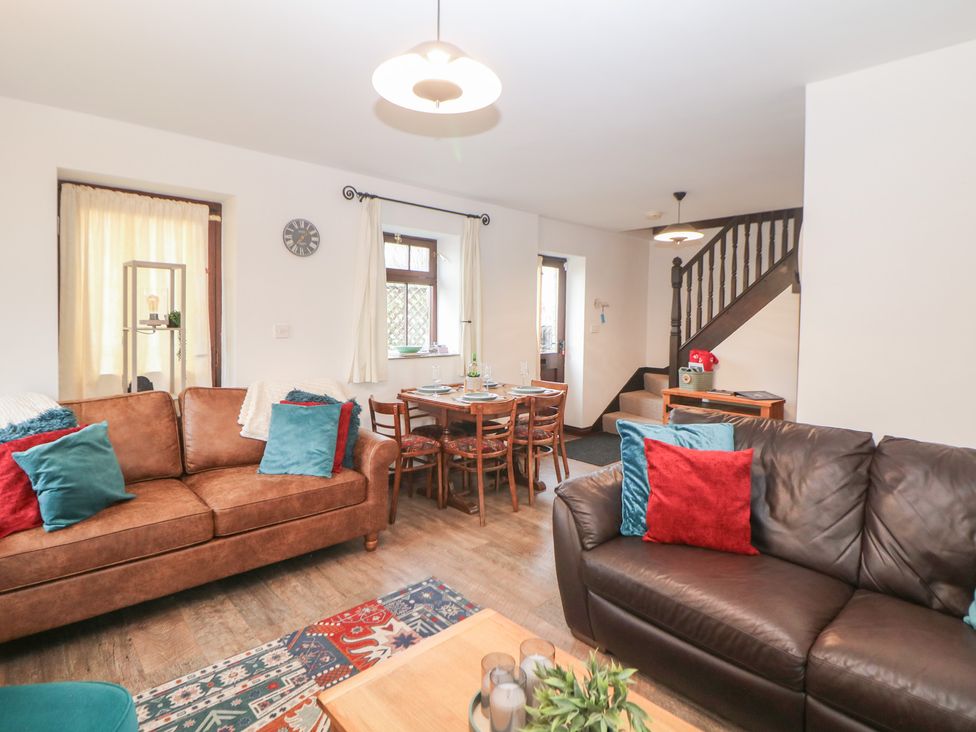 A living room with sofas and a dining table at Win Hill View Cottage in Hope