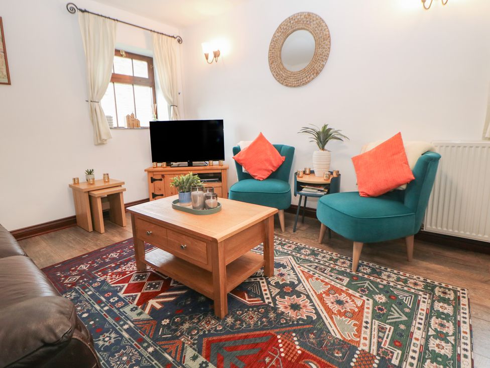 A living room with a coffee table and armchairs at Win Hill View Cottage in Hope