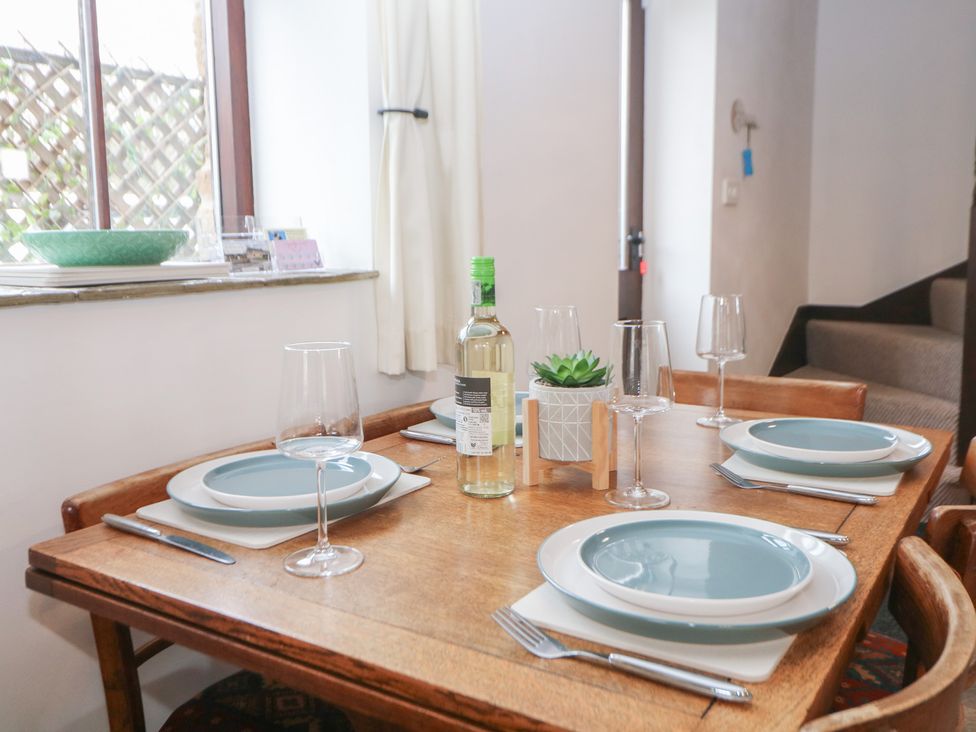 A dining table set with plates and glasses at Win Hill View Cottage in Hope