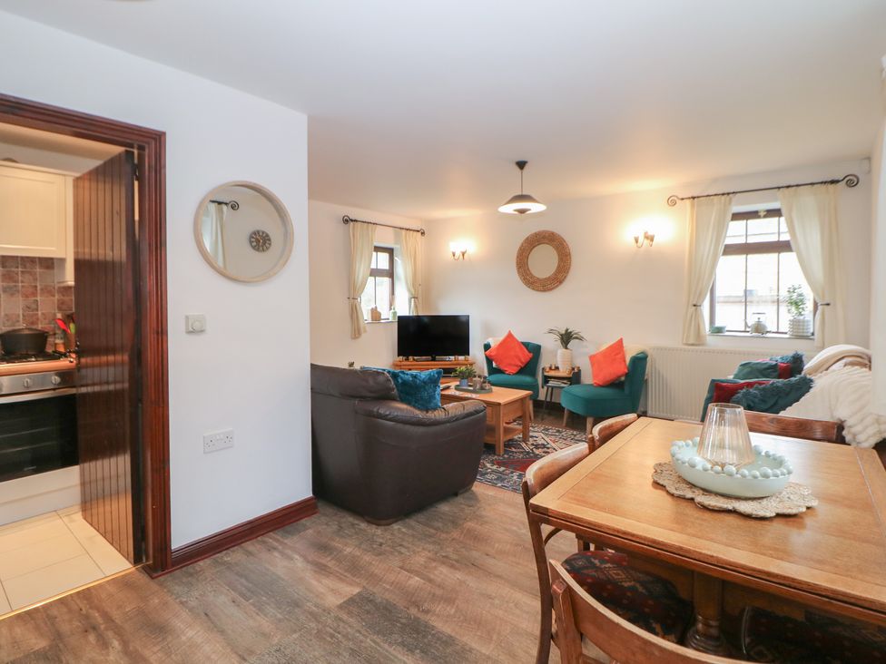 A living room with sofa and dining table at Win Hill View Cottage in Hope
