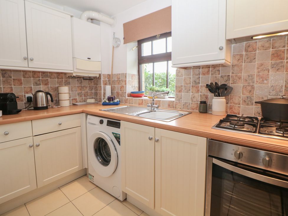 A kitchen with a washing machine and stove at Win Hill View Cottage in Hope