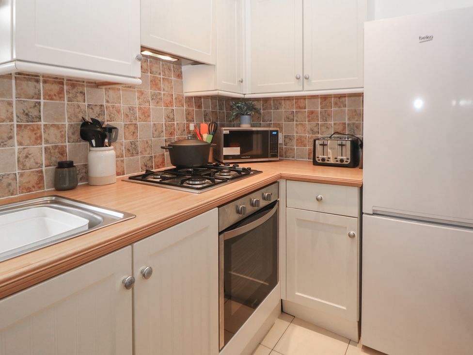 A kitchen featuring a sink, oven, and refrigerator at Win Hill View Cottage in Hope