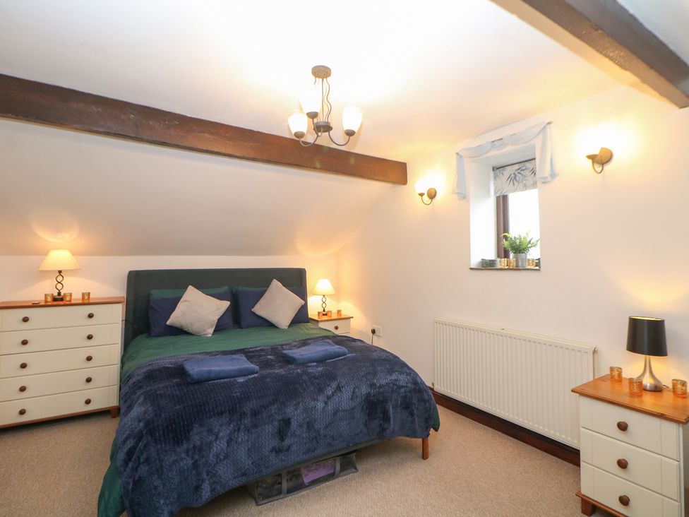 A bedroom with a bed and dresser at Win Hill View Cottage in Hope