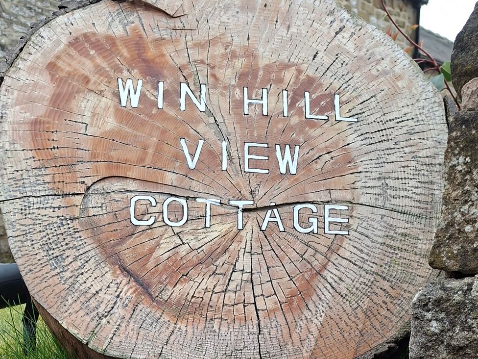 A wooden sign displaying the name Win Hill View Cottage