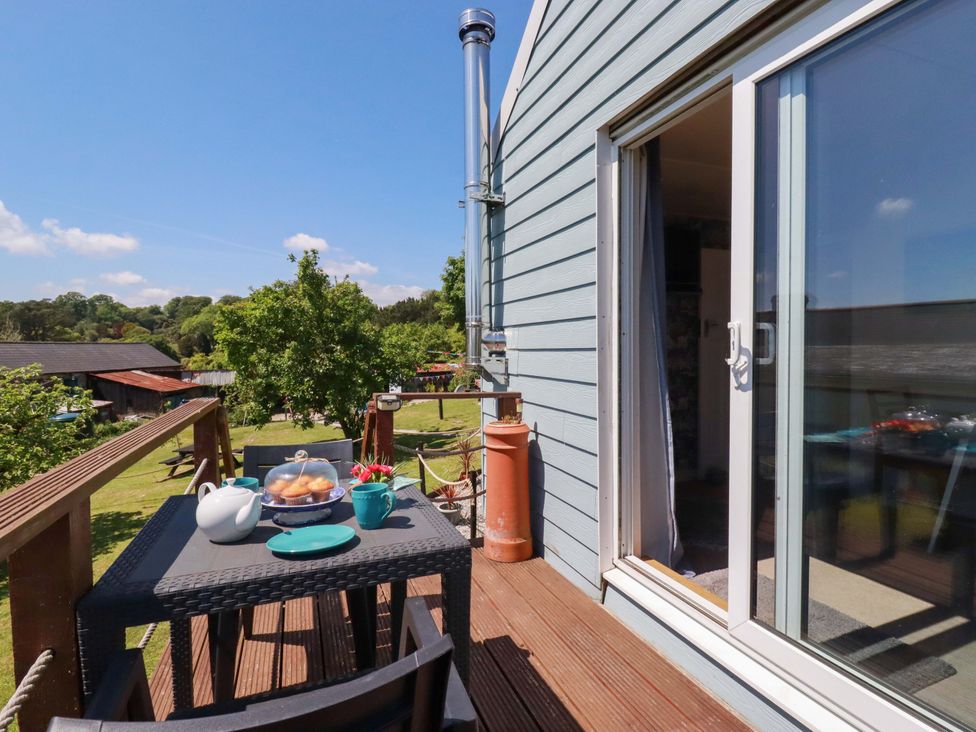 A balcony with a table set for tea at The Studio in Feock near Truro