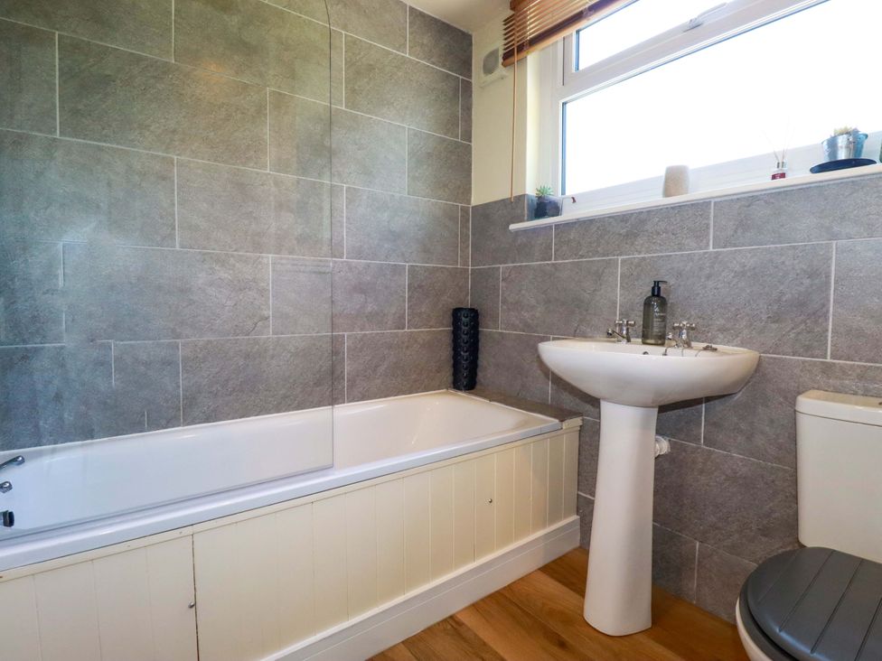 A bathroom with a bathtub, sink, and toilet at The Studio in Feock near Truro
