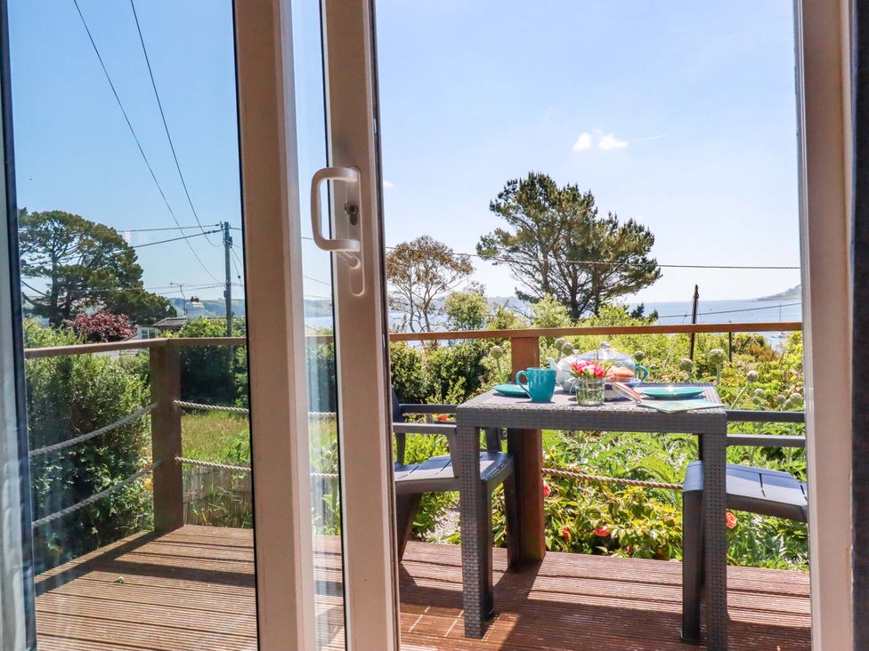 An outdoor area with a table and chairs overlooking the view at The Studio in Feock near Truro