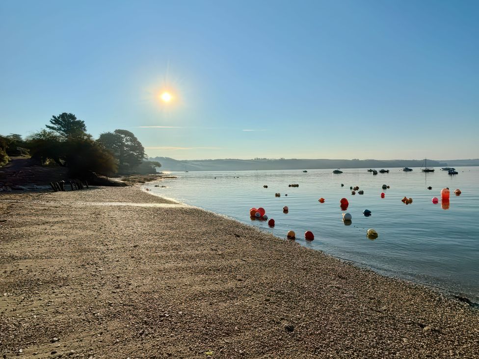 A beach with water and buoys in the bay at The Studio in Feock near Truro