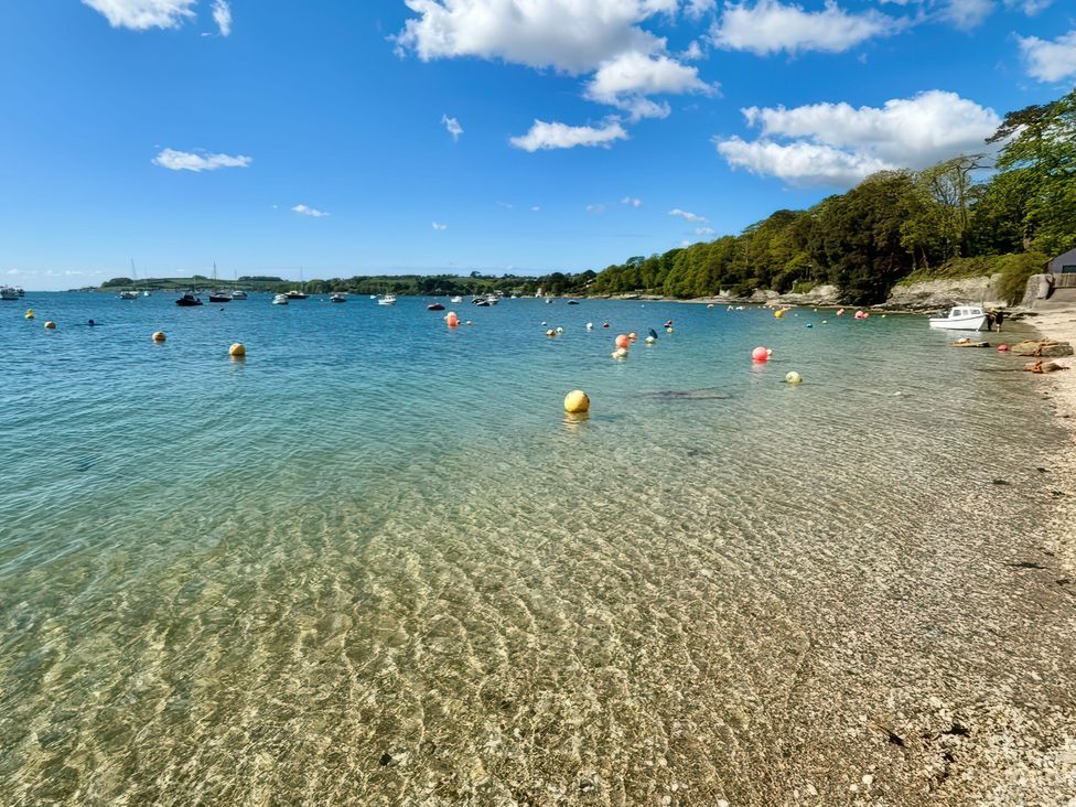A beach with boats and buoys in the water at The Studio in Feock near Truro