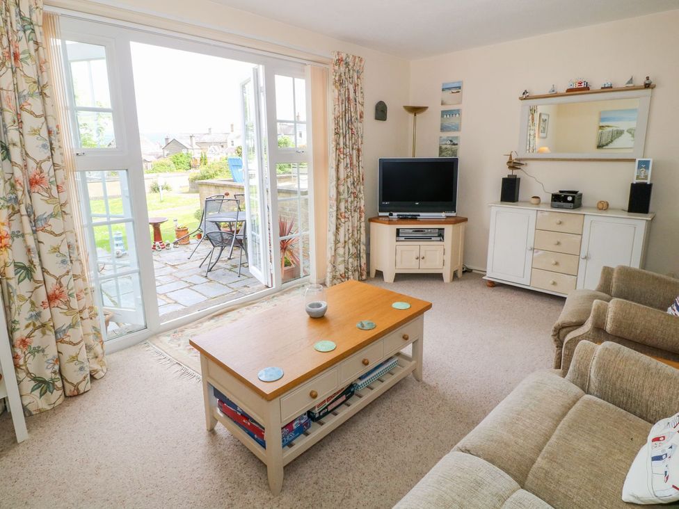 A living room with a TV and coffee table at The Cottage On The Green in Porthmadog