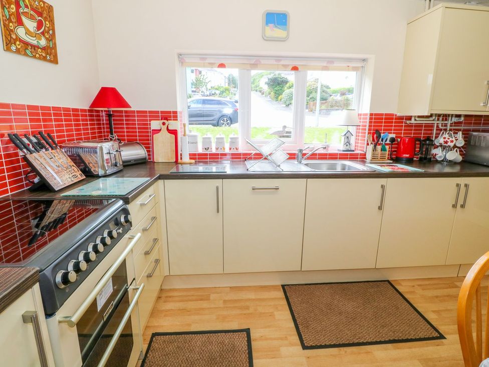 A kitchen with a stove and sink at The Cottage On The Green Porthmadog