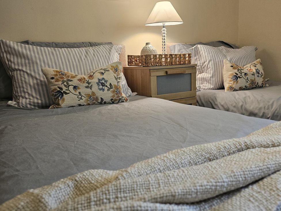 A bedroom with two beds and a nightstand at The Cottage On The Green Borth-Y-Gest