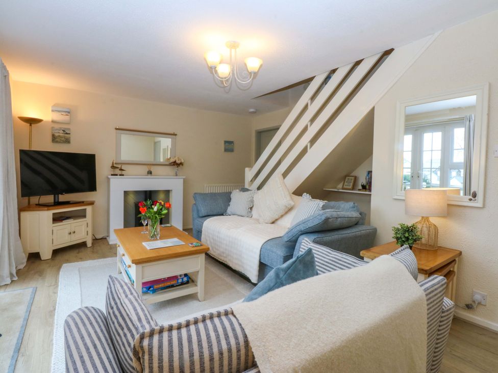 A living room with a sofa and television at The Cottage On The Green Borth-Y-Gest