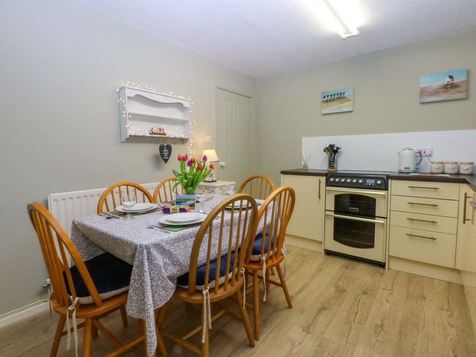 A kitchen with a dining table and chairs at The Cottage On The Green Borth-Y-Gest