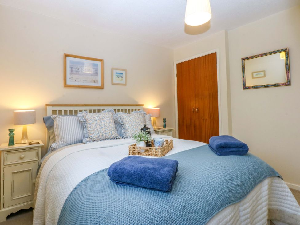 A bedroom with a bed and bedside table at The Cottage On The Green Borth-Y-Gest
