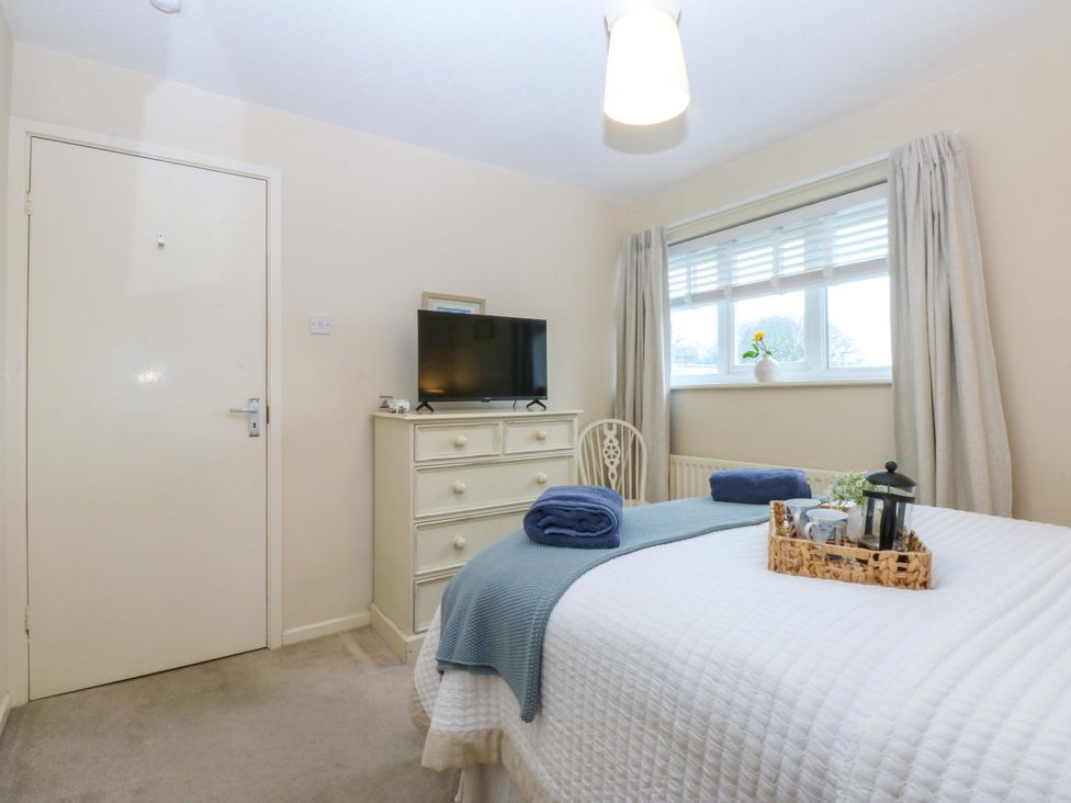 A bedroom with a bed and a television at The Cottage On The Green in Borth-Y-Gest