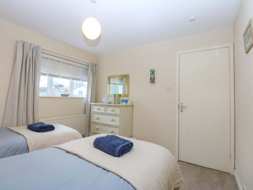 A bedroom with two beds and a dresser at The Cottage On The Green in Borth-Y-Gest