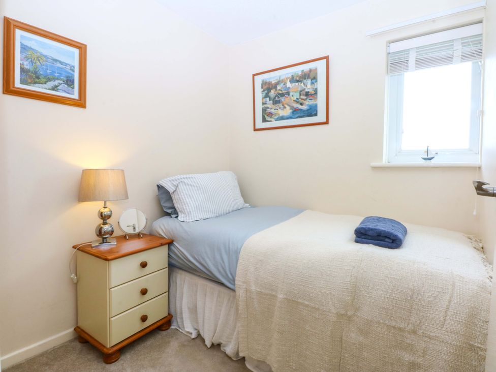 A bedroom with a single bed and bedside table at The Cottage On The Green in Borth-Y-Gest