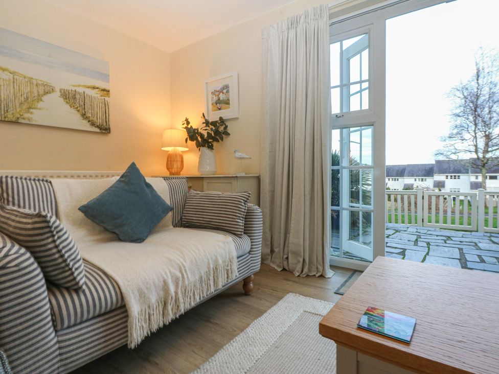 A living room with a sofa and a door to outside at The Cottage On The Green Borth-Y-Gest
