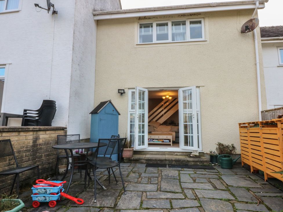 An outdoor area with a table and chairs at The Cottage On The Green in Borth-Y-Gest