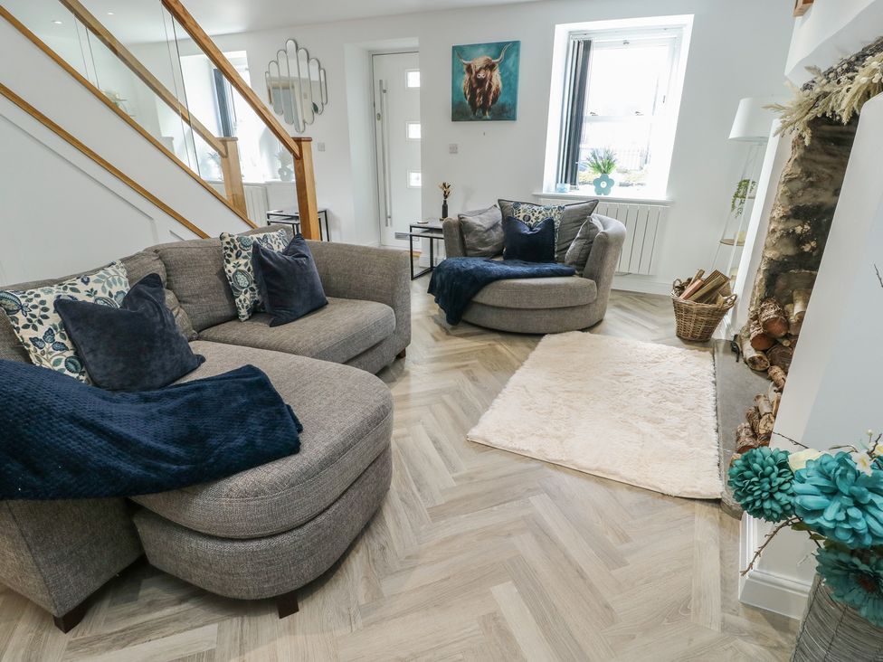 A living room with a sofa and armchair at Rhows in Niwbwrch (Newborough)