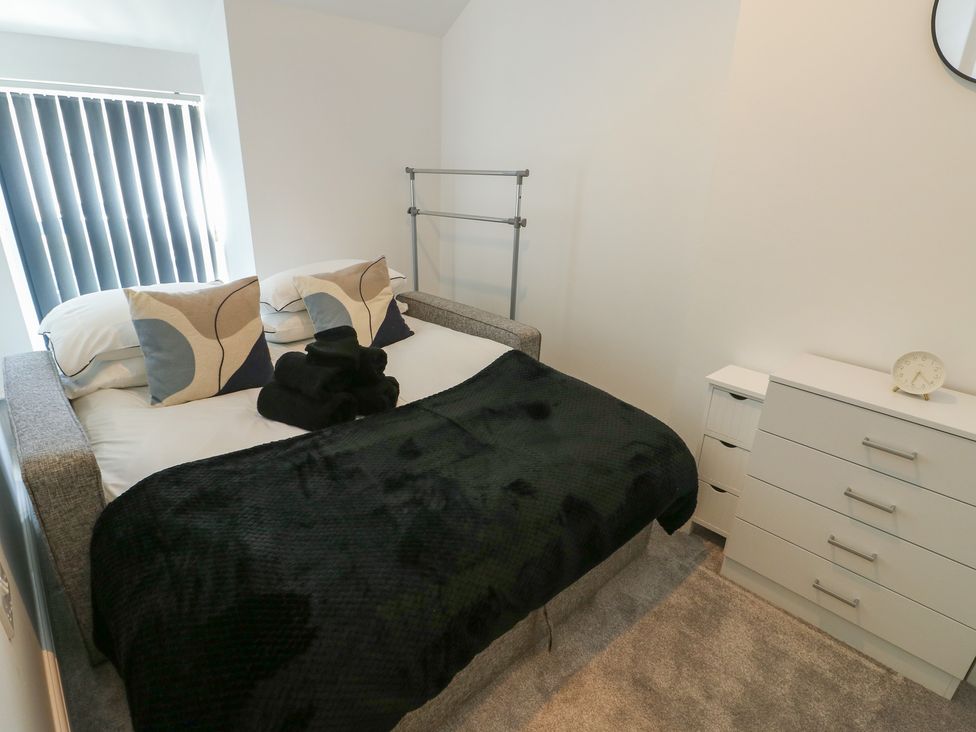 A bedroom with a bed and bedside table at Rhows in Niwbwrch (Newborough)