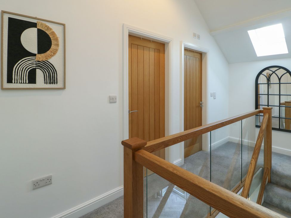 A hallway with doors and a skylight at Rhows, Niwbwrch (Newborough)
