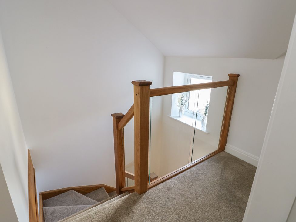 A stairwell with a staircase and a window at Hen Siop in Niwbwrch (Newborough)