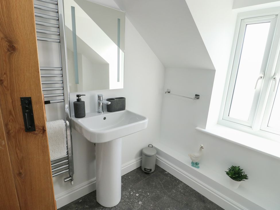 A bathroom with a sink and mirror at Hen Siop in Niwbwrch (Newborough)