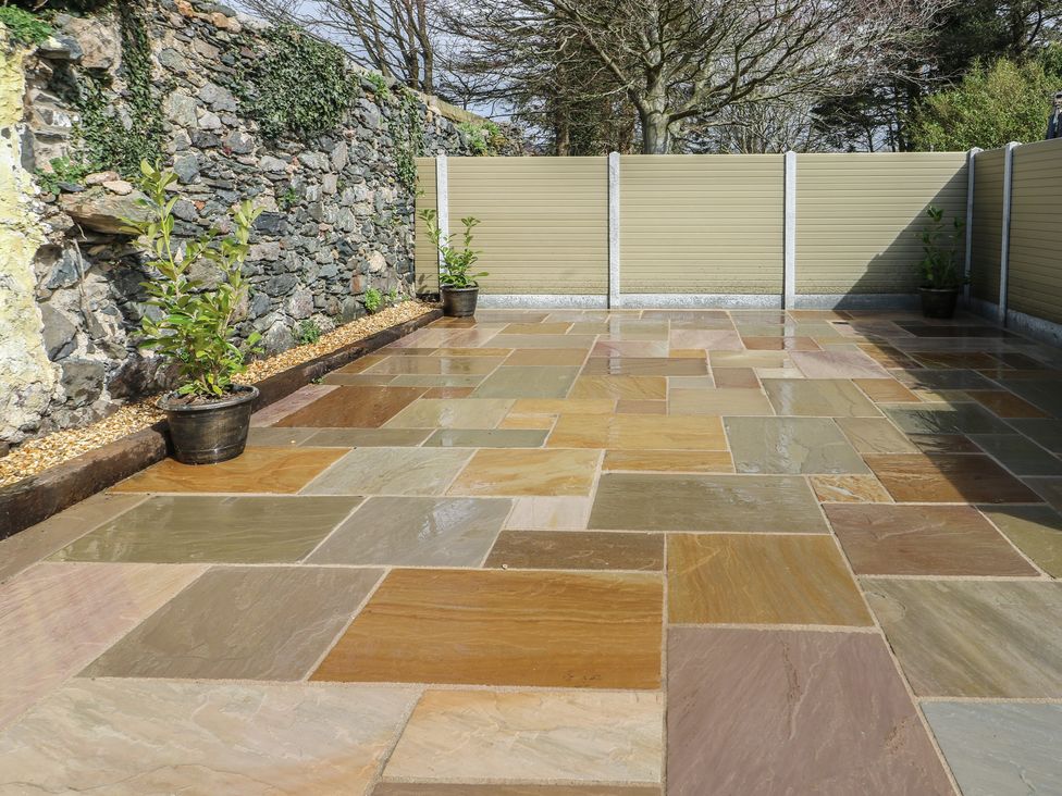 An outdoor patio with paving stones and plants at Hen Siop in Niwbwrch (Newborough)