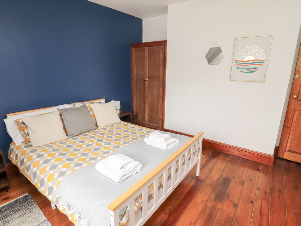 A bedroom with a bed and wardrobe at 1 Cleator Gate in Cleator