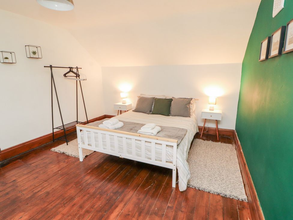 A bedroom with a bed and nightstand at 1 Cleator Gate in Cleator