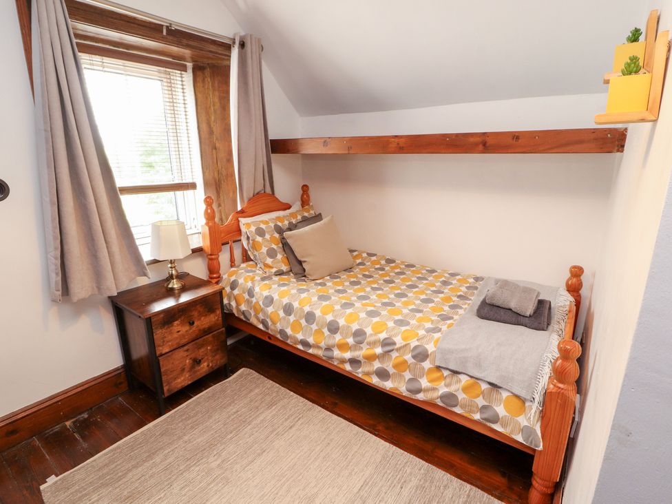 A bedroom with a single bed and nightstand at 1 Cleator Gate in Cleator