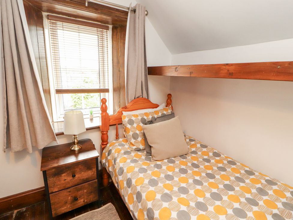 A bedroom with a bed and nightstand at 1 Cleator Gate in Cleator