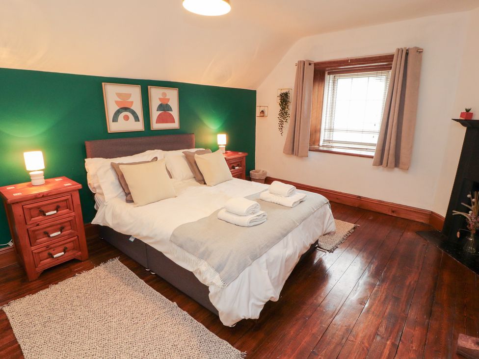A bedroom with a bed and bedside tables at 1 Cleator Gate in Cleator