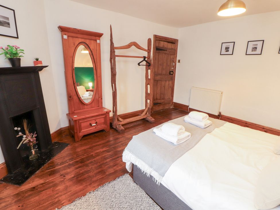 A bedroom with a bed and mirror at 1 Cleator Gate Cleator