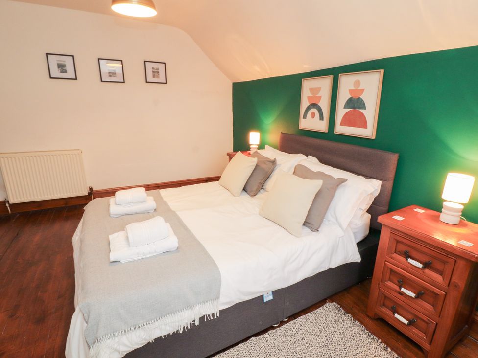 A bedroom with a bed and nightstand at 1 Cleator Gate in Cleator