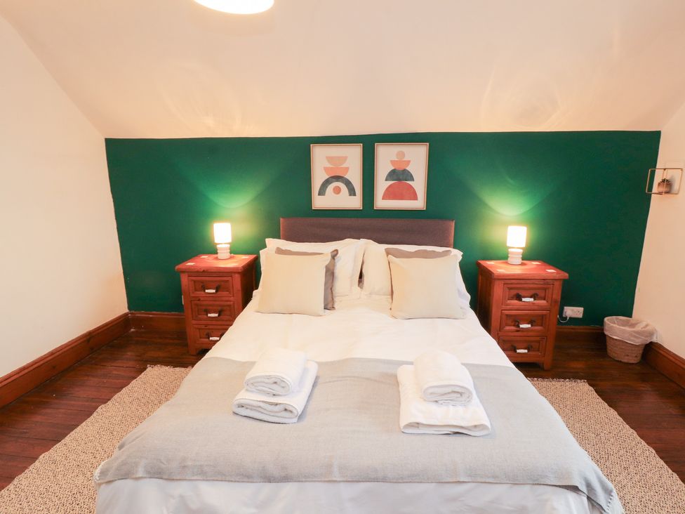 A bedroom with a bed and bedside tables at 1 Cleator Gate in Cleator