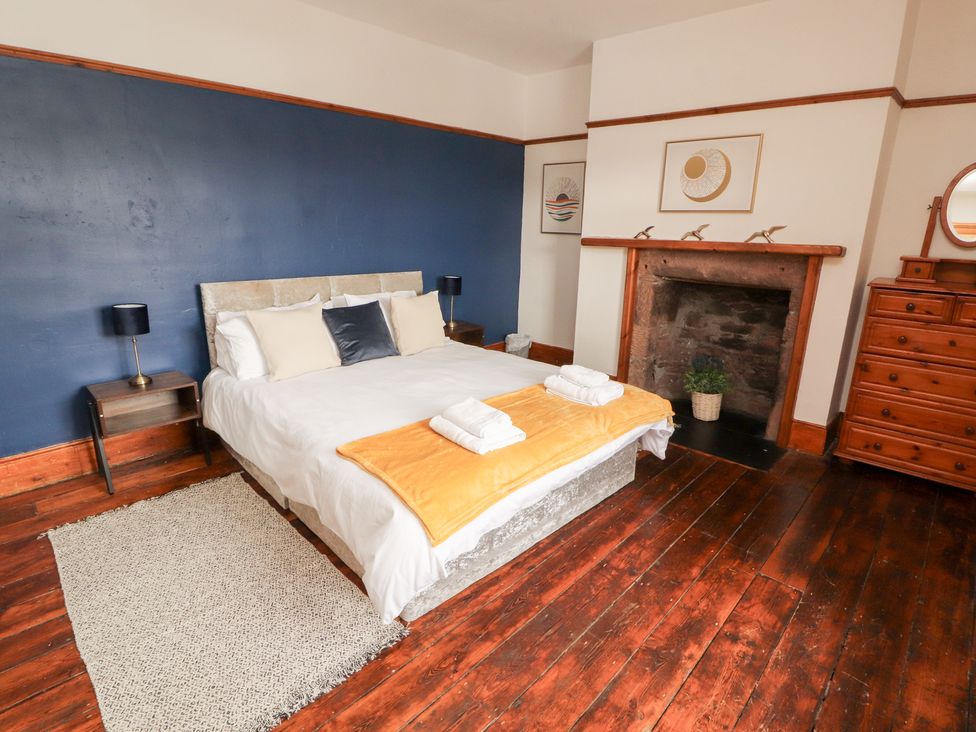 A bedroom with a bed and bedside tables at 1 Cleator Gate, Cleator