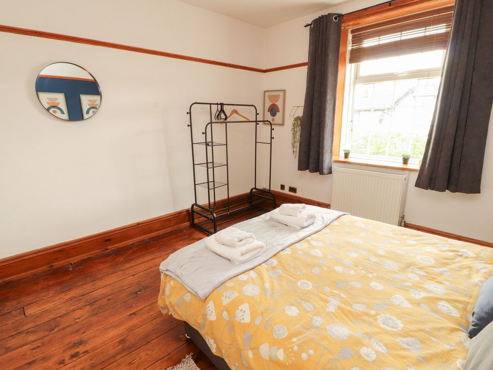 A bedroom with a bed and coat rack at 1 Cleator Gate, Cleator