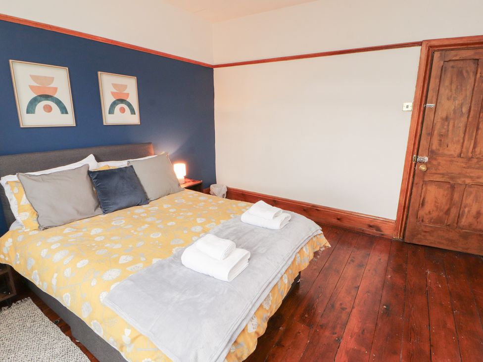 A bedroom with a bed and wall art at 1 Cleator Gate in Cleator
