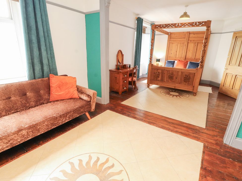 A bedroom with a bed and sofa at 1 Cleator Gate in Cleator