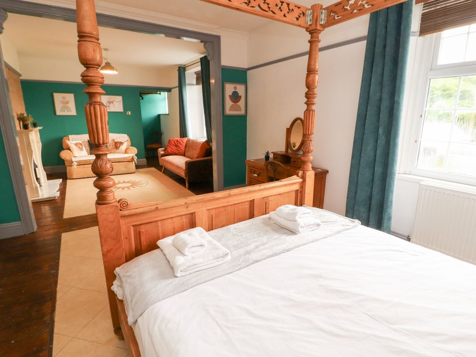 A bedroom with a four-poster bed and dressing table at 1 Cleator Gate in Cleator